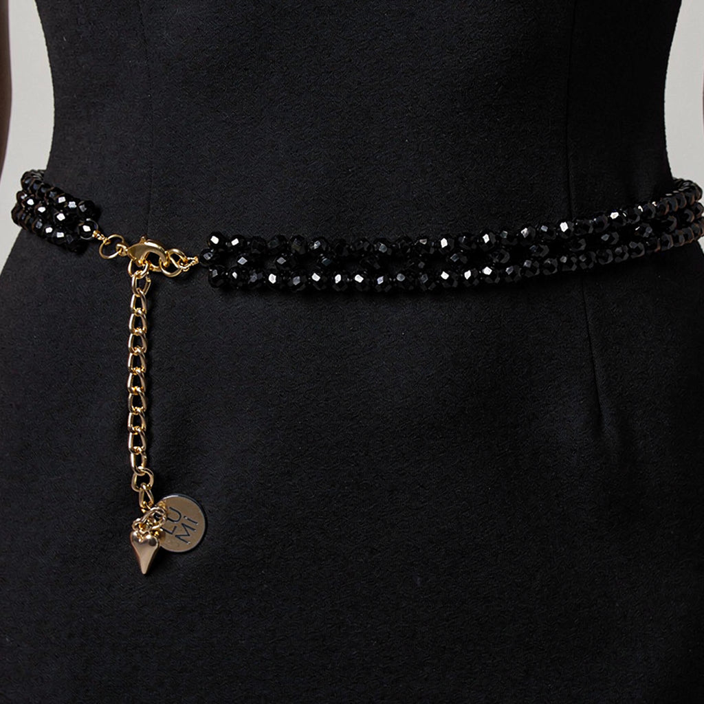 Model wearing the handmade LUMI black crystal waist belt with elegant gold-tone details.