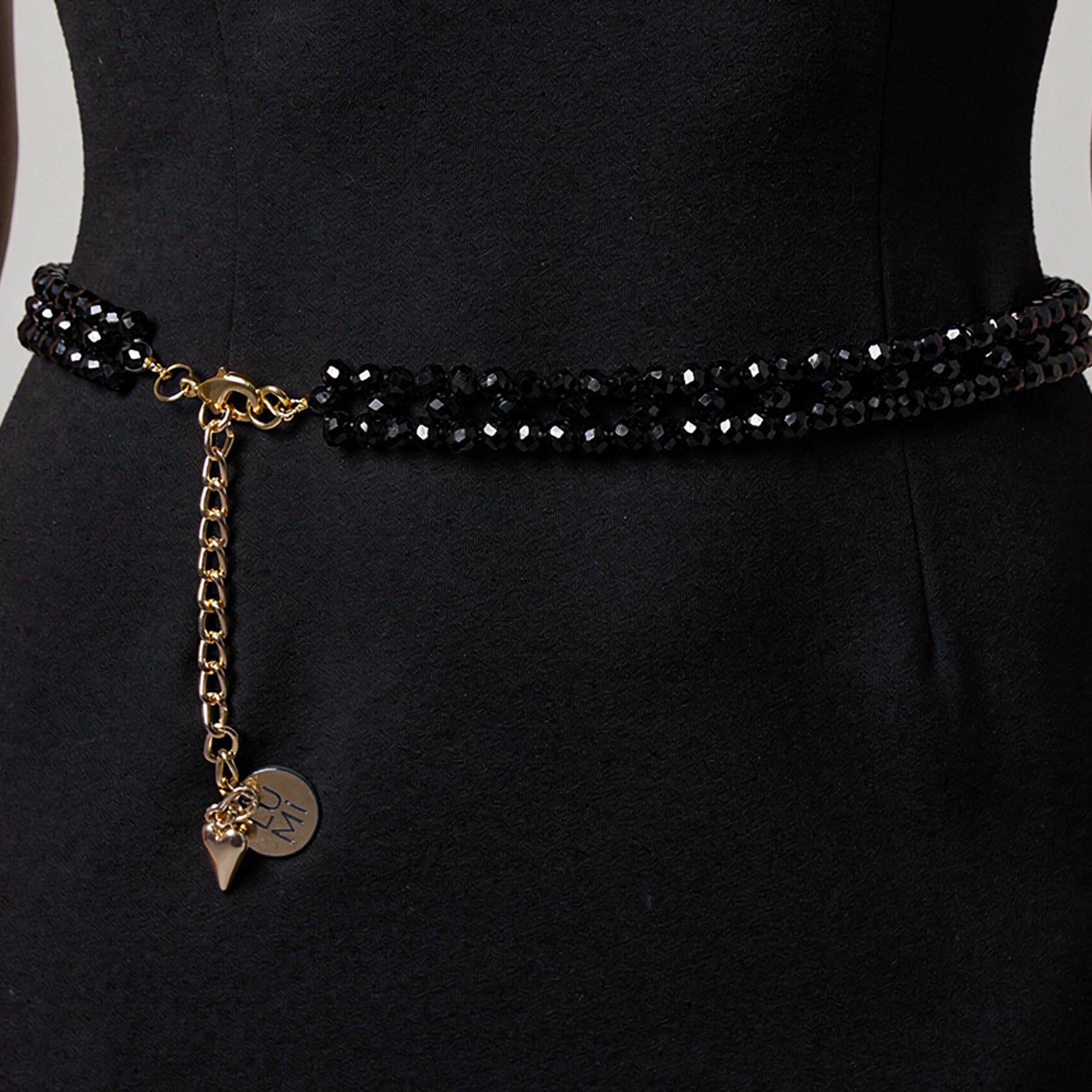 Model wearing the handmade LUMI black crystal waist belt with elegant gold-tone details.