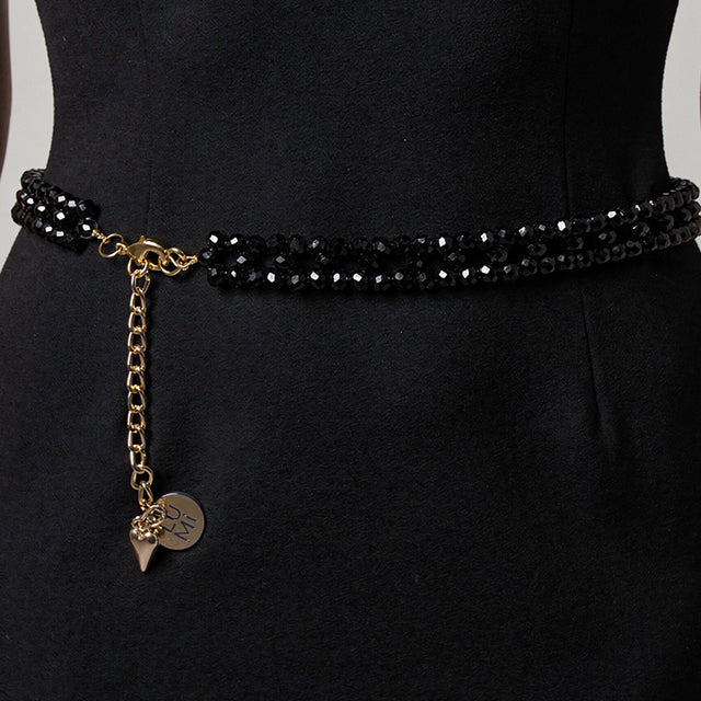 Model wearing the handmade LUMI black crystal waist belt with elegant gold-tone details.