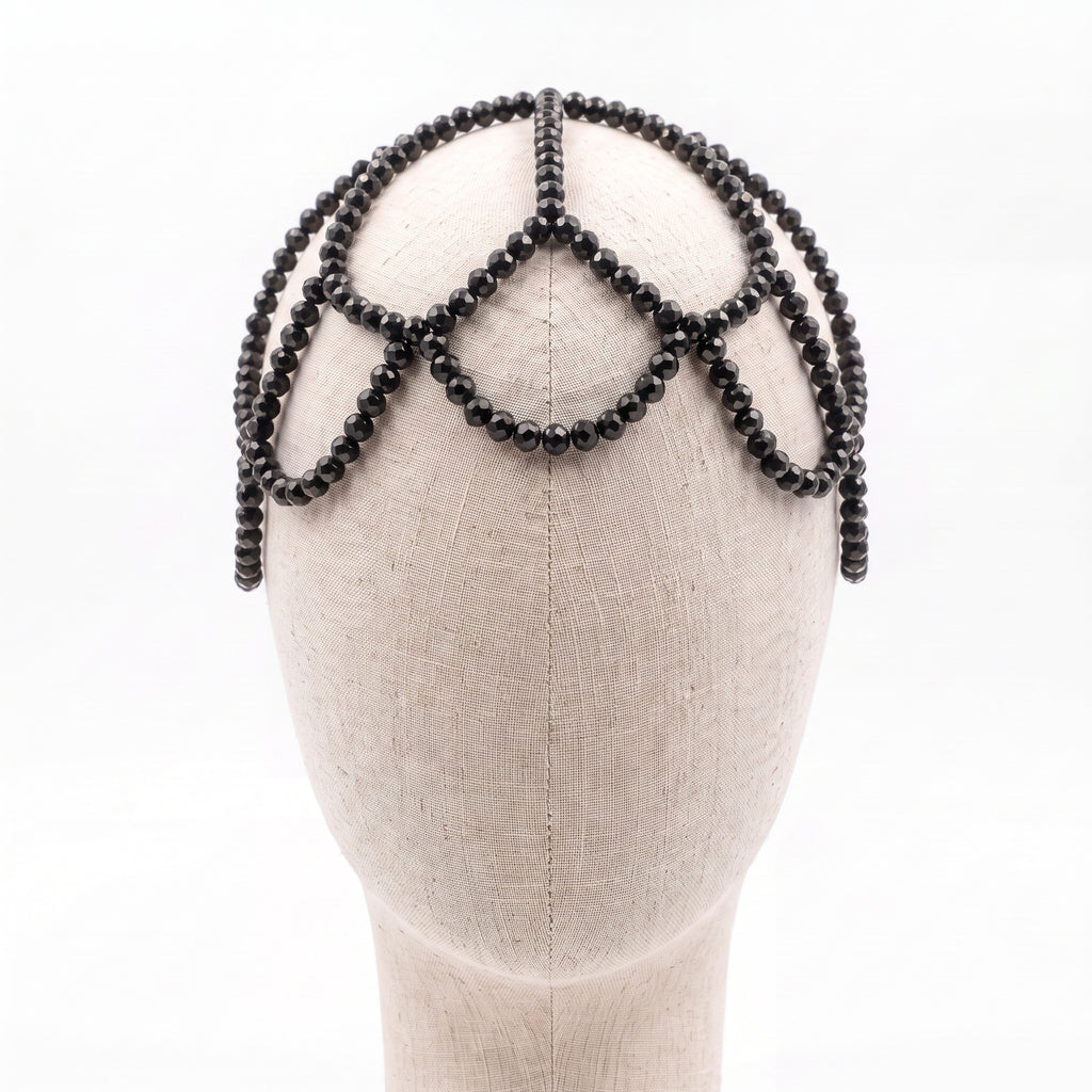 Handmade black crystal headpiece displayed on a mannequin showcasing its elegant draped silhouette.
