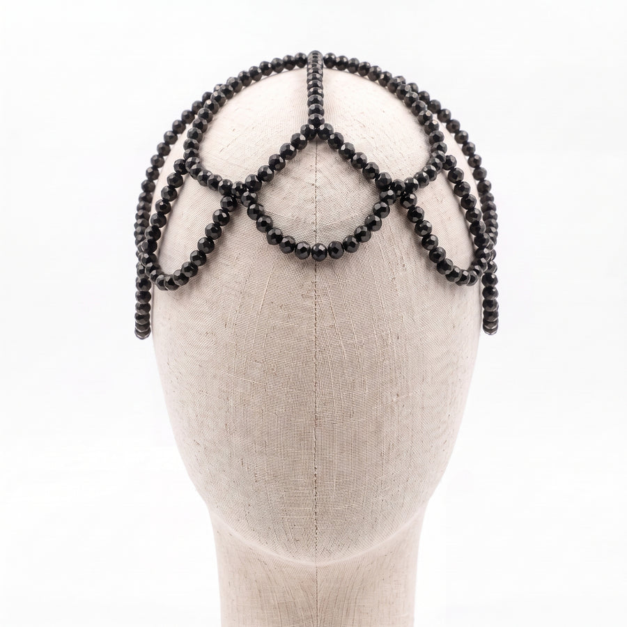 Handmade black crystal headpiece displayed on a mannequin showcasing its elegant draped silhouette.