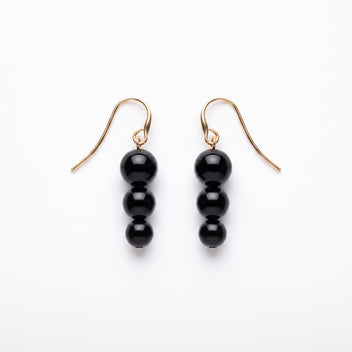 Noir Cascade black bead drop earrings on a white background