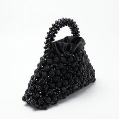 Angled view of the Velvet Caviar black crystal bag, handle and satin lining
