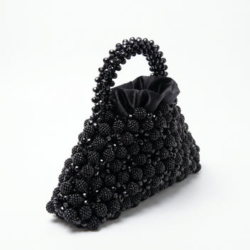 Angled view of the Velvet Caviar black crystal bag, handle and satin lining