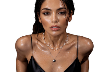 Model wearing a layered pearl necklace with silver heart pendant