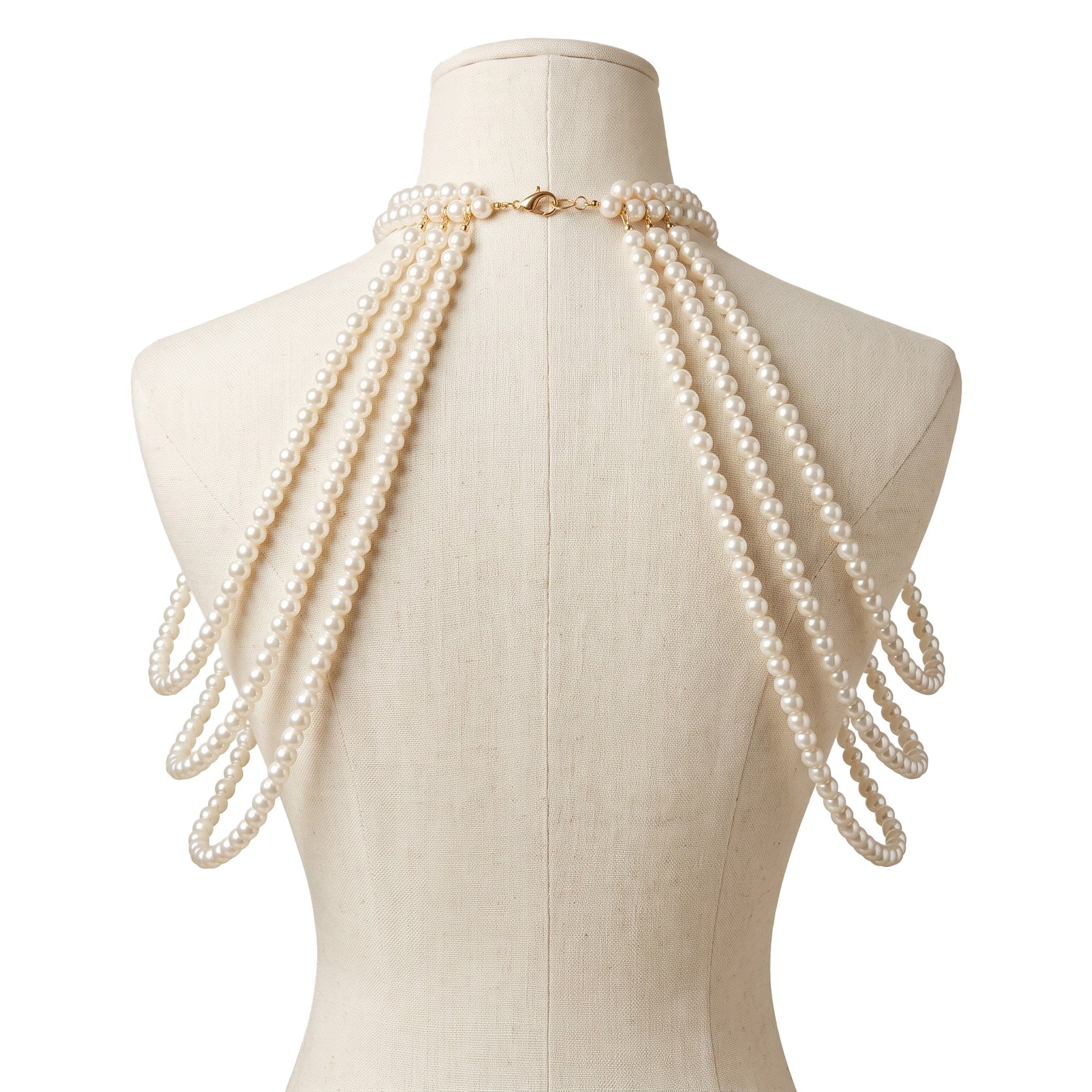 Back view of the LUMI Ivory Pearl Shoulder Necklace with layered ivory pearl strands and gold clasp on a mannequin