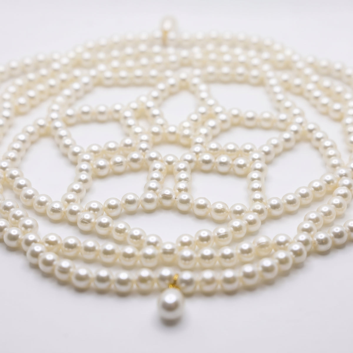 Close-up of the Aurelia ivory pearl headpiece, woven pearl lattice and teardrop details