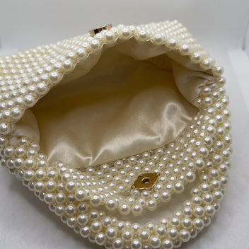 Interior detail of The Nacre Bag showing the satin lining, magnetic closure and pearl construction.