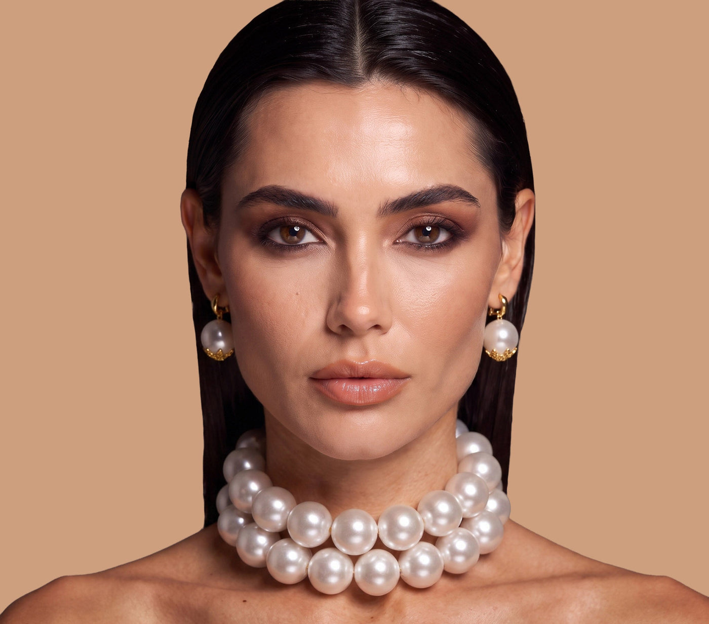 Elegant model wearing LUMI handmade oversized pearl choker with matching pearl earrings in a luxury editorial portrait.
