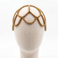 Gold crystal handmade headpiece displayed on a mannequin highlighting its crown-inspired silhouette.