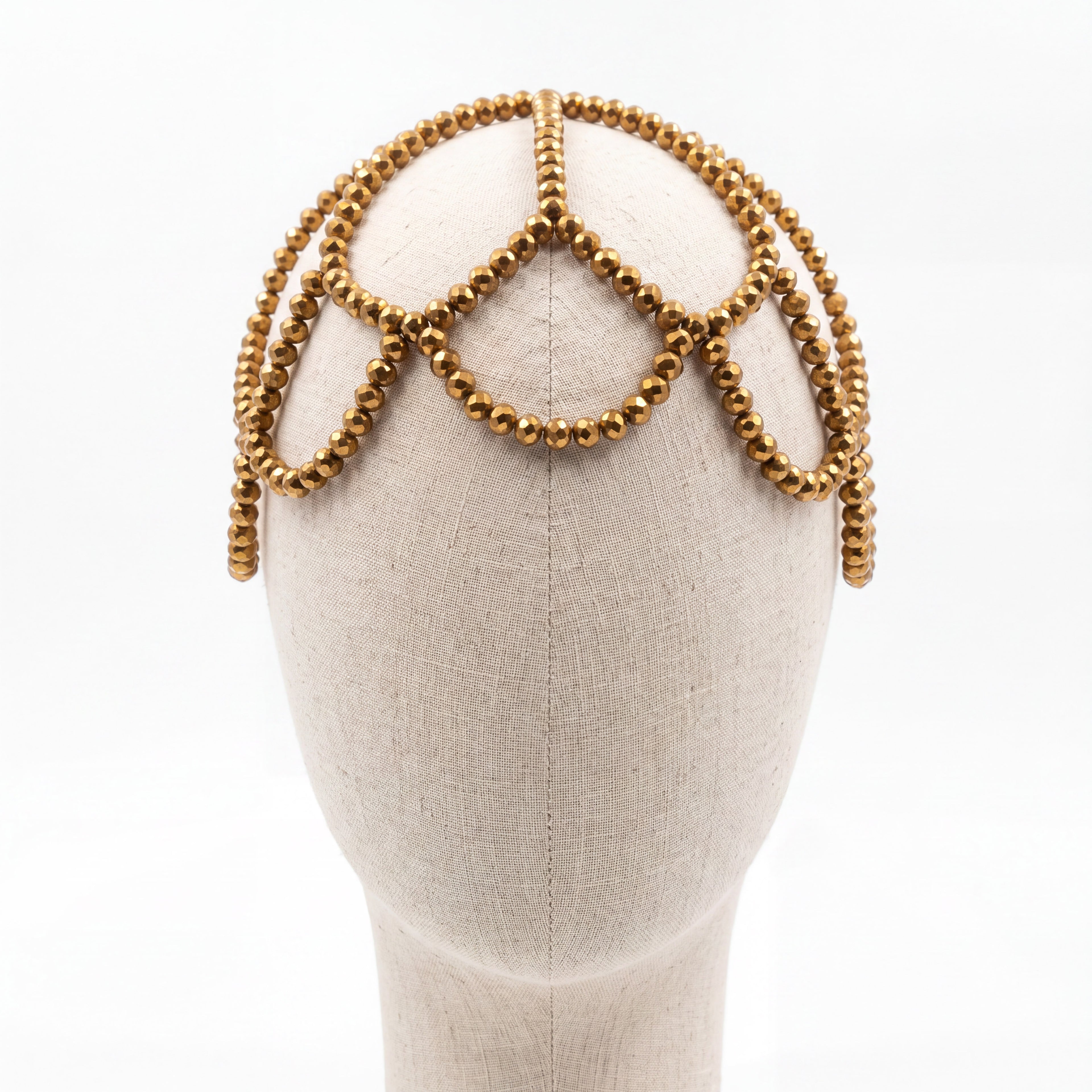 Gold crystal handmade headpiece displayed on a mannequin highlighting its crown-inspired silhouette.