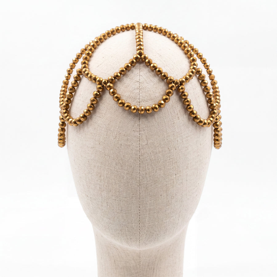 Gold crystal handmade headpiece displayed on a mannequin highlighting its crown-inspired silhouette.