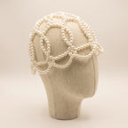 Angled view of the Aurelia White Pearl Headpiece showing its sculptural white pearl lattice design.