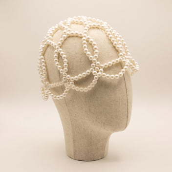 Angled view of the Aurelia White Pearl Headpiece showing its sculptural white pearl lattice design.