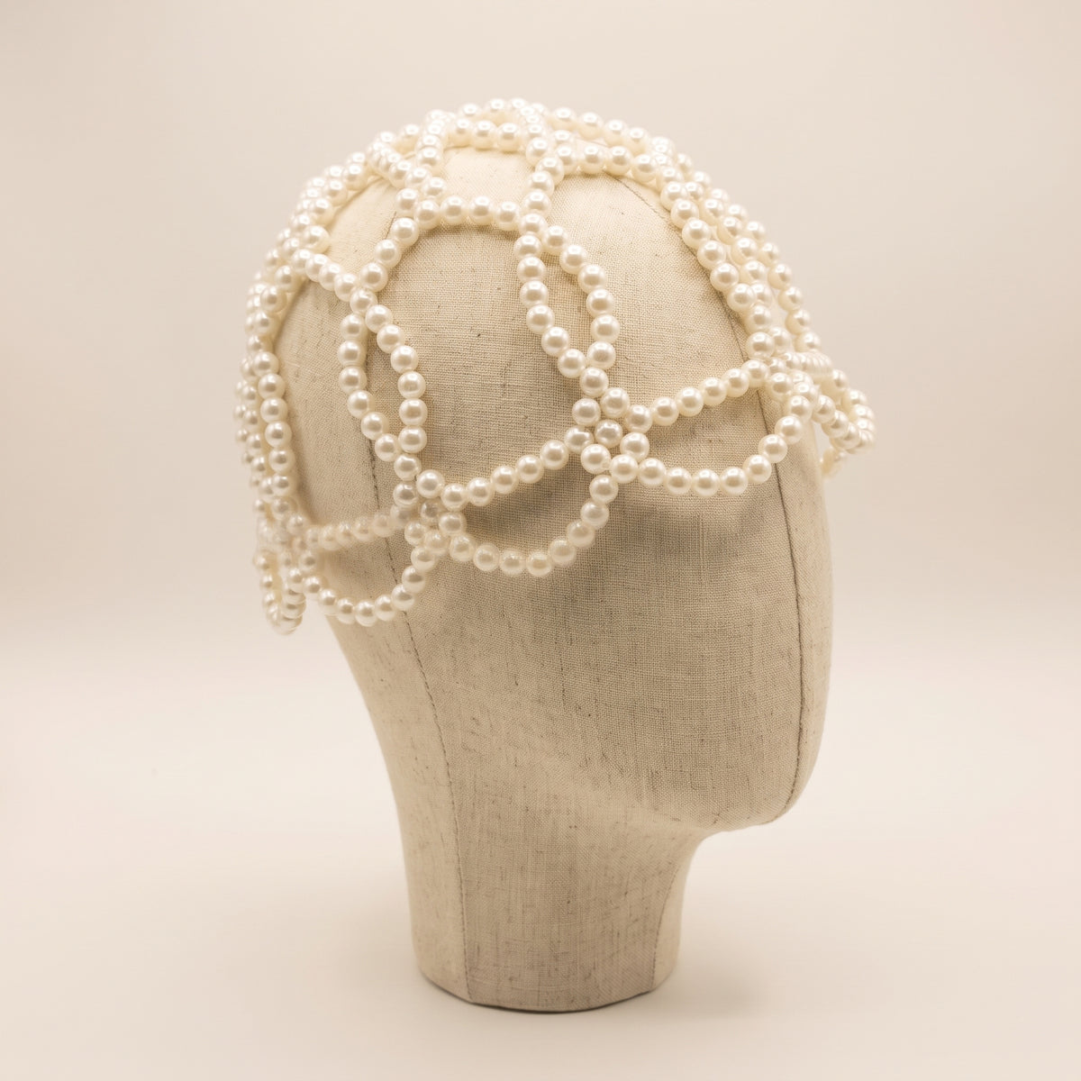 Angled view of the Aurelia White Pearl Headpiece showing its sculptural white pearl lattice design.