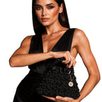 Model holding the Velvet Caviar black crystal bag