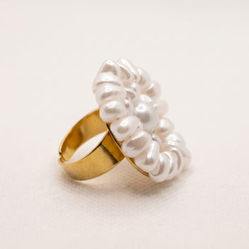 Side view of the handmade Alba Pearl Bloom Ring by LUMI, showing its dimensional white pearl arrangement and polished gold-tone adjustable metal band.
