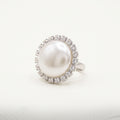 Handmade Celestia Pearl Halo Ring – White by LUMI, featuring a large white pearl surrounded by clear glass crystals in a polished silver-tone metal setting against a white background.