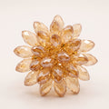 Handmade Champagne Crystal Bloom Ring by LUMI, featuring a sculptural floral design with faceted champagne glass crystals and gold-tone detailing on a white background.