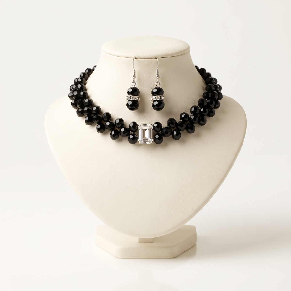Handmade Éclipse Crystal Choker Jewelry Set – Noir by LUMI, featuring a black glass crystal necklace with a rectangular clear crystal centerpiece and matching silver-tone drop earrings displayed on an ivory jewelry bust.