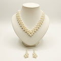 The Elara Pearl Jewelry Set by LUMI featuring a handmade ivory pearlescent necklace displayed on a cream jewelry bust with matching pearl drop earrings.