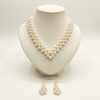 The Elara Pearl Jewelry Set by LUMI featuring a handmade ivory pearlescent necklace displayed on a cream jewelry bust with matching pearl drop earrings.