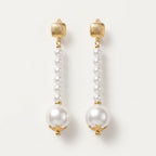 Pair of Éloise Pearl Drop Earrings by LUMI, featuring small white pearl beads arranged in elongated drops, larger pearl accents, textured gold-tone tops and decorative gold-tone caps.
