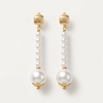 Pair of Éloise Pearl Drop Earrings by LUMI, featuring small white pearl beads arranged in elongated drops, larger pearl accents, textured gold-tone tops and decorative gold-tone caps.