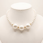 Close-up of LUMI's handmade Éloise Pearl Trio Necklace, highlighting three large luminous white pearls surrounded by smaller round pearl beads and polished gold-tone spacer accents.