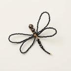 Alternative studio view of the handmade Libellule Navy Crystal Dragonfly Brooch by LUMI, showing its four symmetrical wings, faceted crystal beads and slender beaded body against a white background.