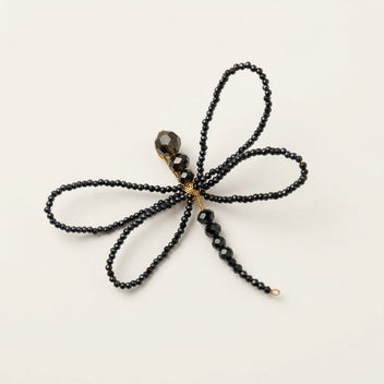 Alternative studio view of the handmade Libellule Navy Crystal Dragonfly Brooch by LUMI, showing its four symmetrical wings, faceted crystal beads and slender beaded body against a white background.