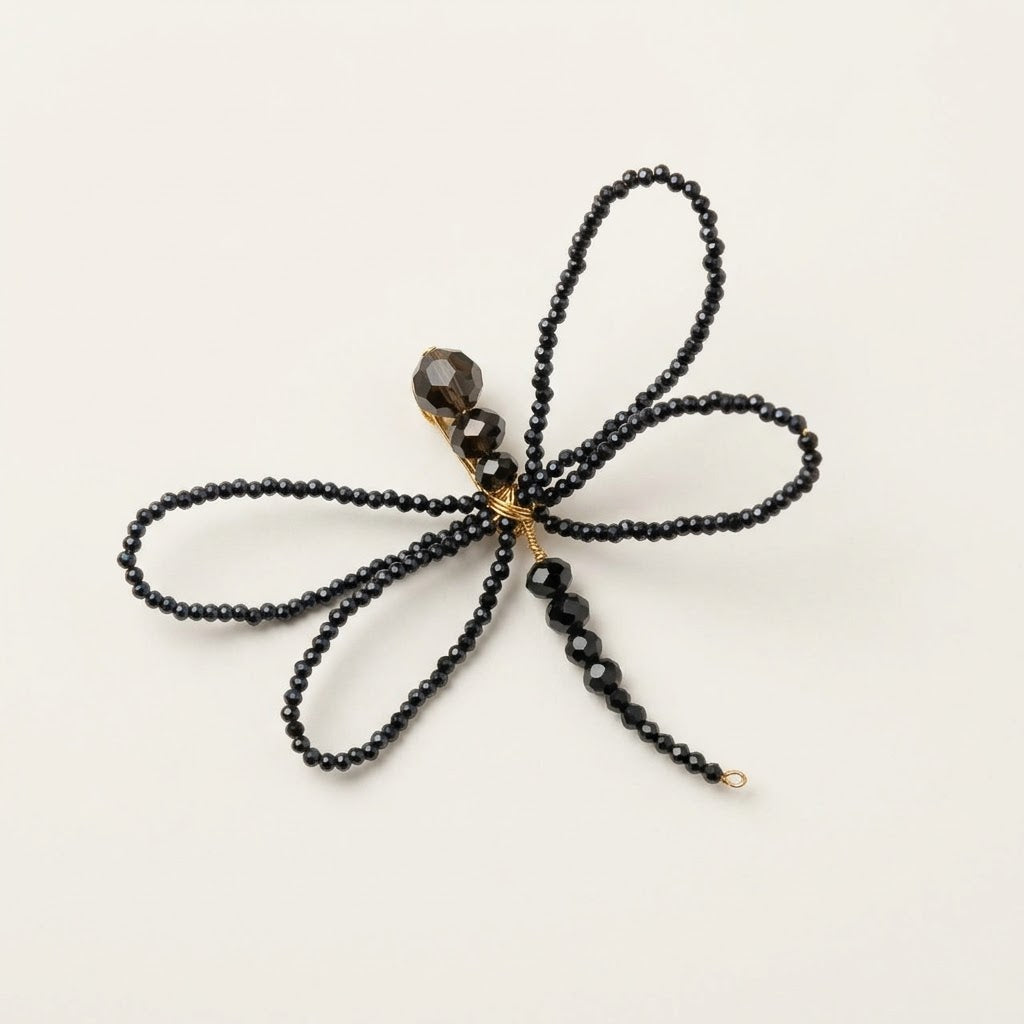 Alternative studio view of the handmade Libellule Navy Crystal Dragonfly Brooch by LUMI, showing its four symmetrical wings, faceted crystal beads and slender beaded body against a white background.