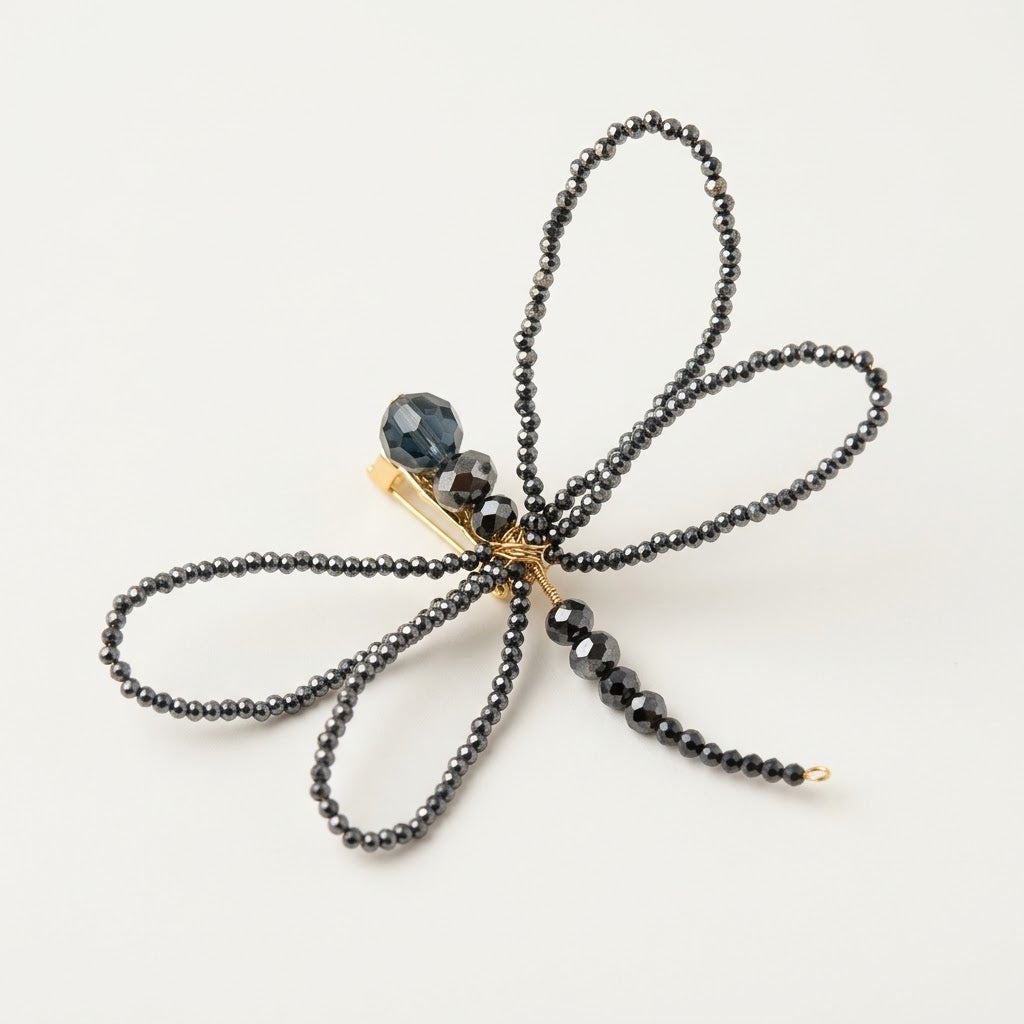 Handmade Libellule Navy Crystal Dragonfly Brooch by LUMI, featuring four delicate wings crafted from faceted glass crystal beads, a slender beaded body and gold-tone wirework on a white background.
