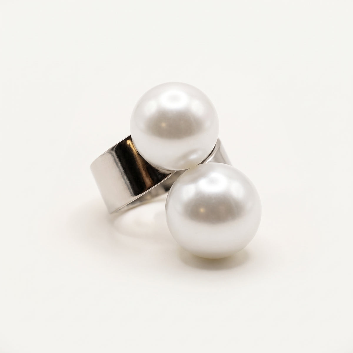 Handmade Solène Double Pearl Ring – White by LUMI, featuring two large white pearls on a wide polished silver-tone adjustable metal band against a white studio background.