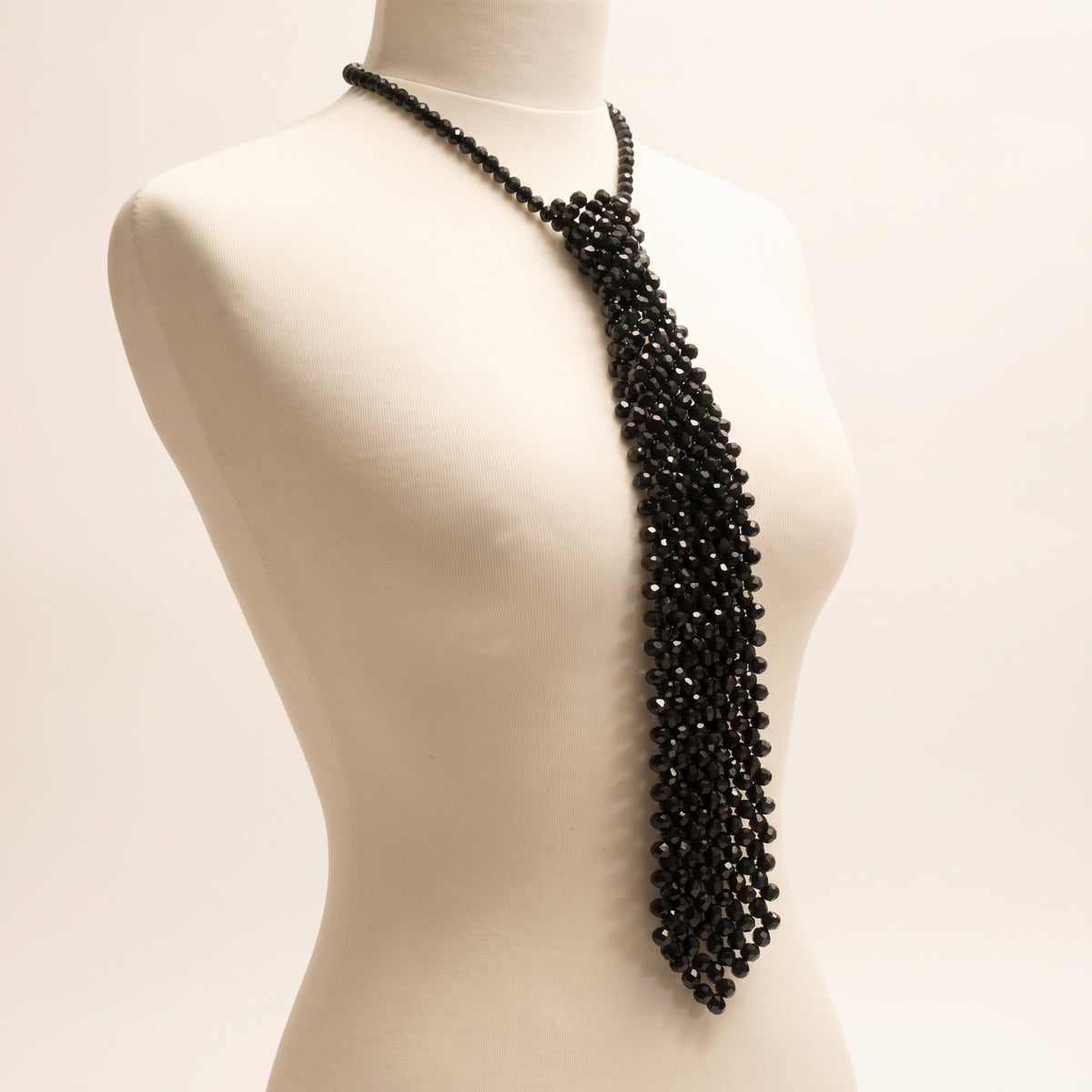 Angled view of the handmade Midnight Crystal Necktie in Noir showing its black glass crystal construction and elongated silhouette.