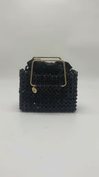 Video of the LUMI Noir Étoile Crystal Handbag, featuring black crystal beading, a polished gold-tone handle, and black satin lining.
