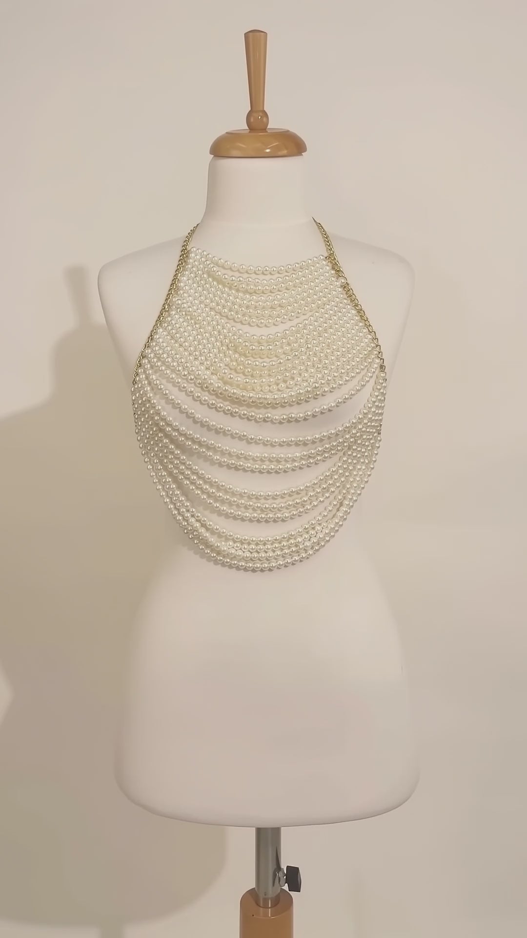 LUMI handmade pearl body top displayed on a mannequin, featuring cascading ivory pearl strands and an elegant draped design.