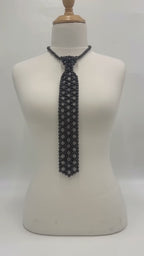 The Onyx Pearl Necktie in black pearls with an adjustable chain, shown in a studio product video.