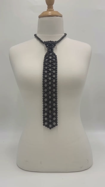 The Onyx Pearl Necktie in black pearls with an adjustable chain, shown in a studio product video.