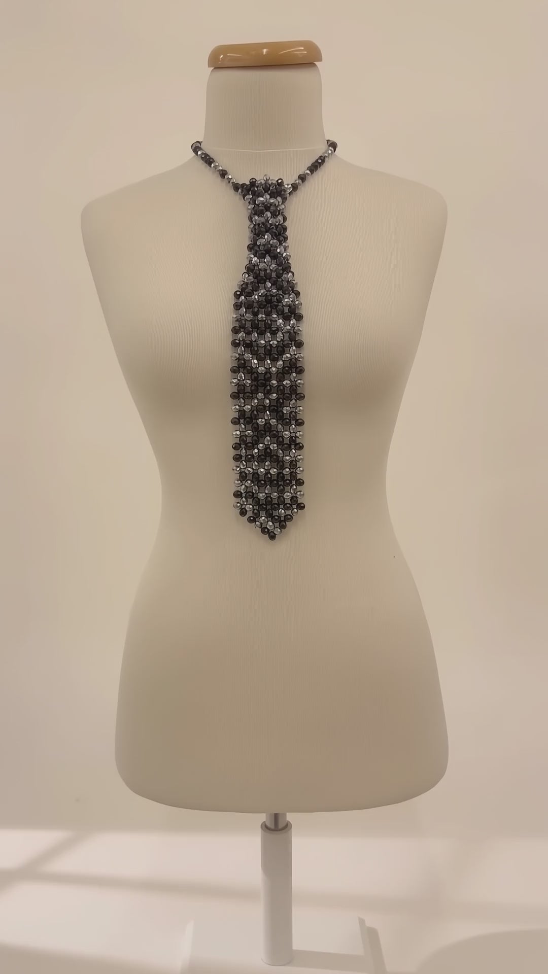 Video of the Cravate de Lumière by LUMI showing the black and silver crystal necktie, adjustable chain and light-catching beadwork from multiple angles.