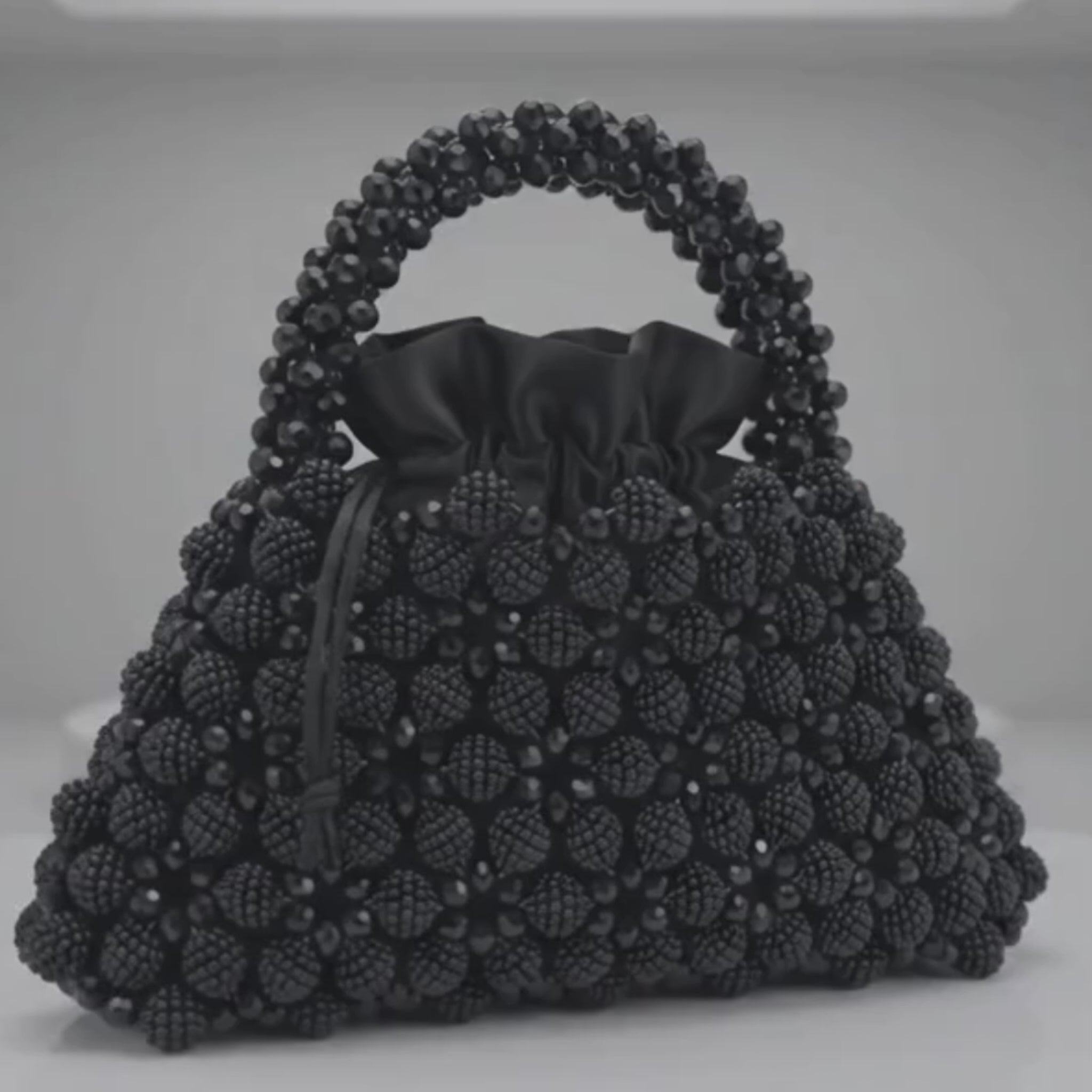 Close-up of the handmade black crystal handbag showcasing its crystal bead craftsmanship and elegant design.