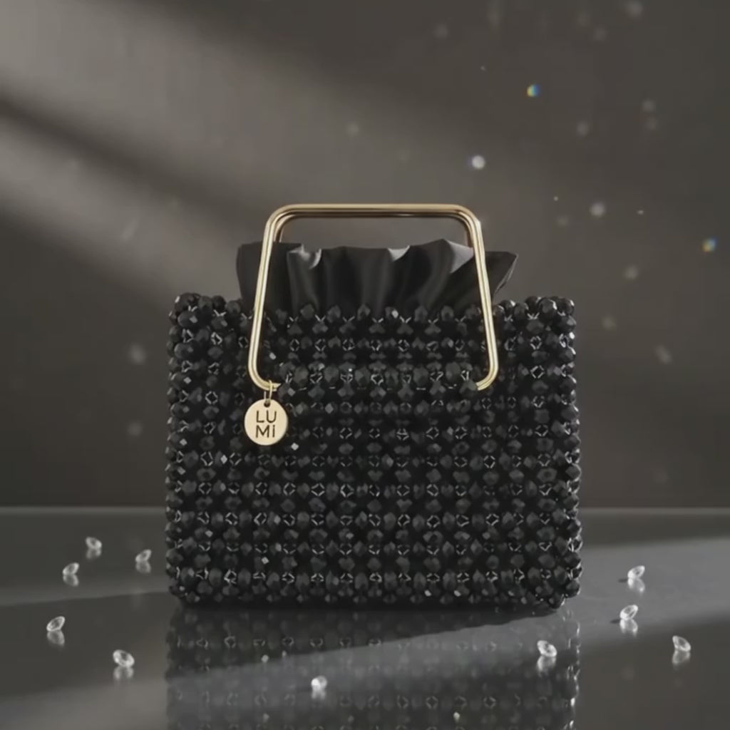 Close-up of the handmade black crystal handbag showing crystal craftsmanship and gold-tone handle.