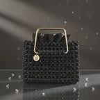 Close-up of the Noir Étoile bag, crystal beads and gold-tone handle