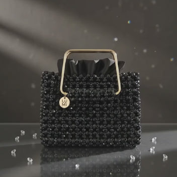 Close-up of the Noir Étoile bag, crystal beads and gold-tone handle