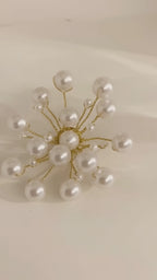 Video of the handmade Astra Pearl Burst Brooch by LUMI showing its white pearl beads and sculptural gold-tone branches from multiple angles.