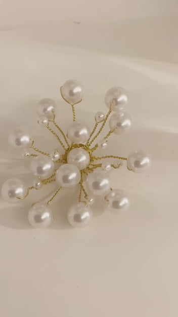 Video of the handmade Astra Pearl Burst Brooch by LUMI showing its white pearl beads and sculptural gold-tone branches from multiple angles.