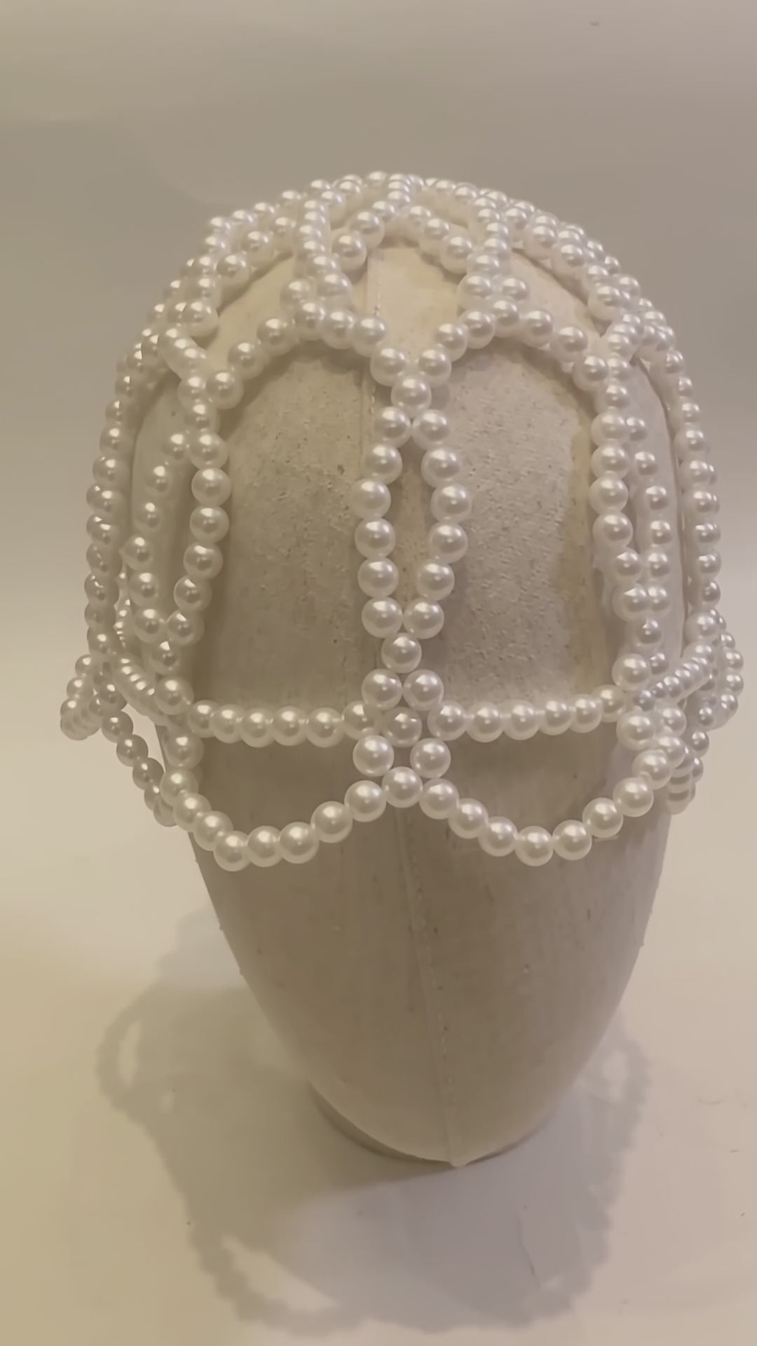 Video of the handmade Aurelia White Pearl Headpiece showing its sculptural white pearl lattice design from multiple angles.